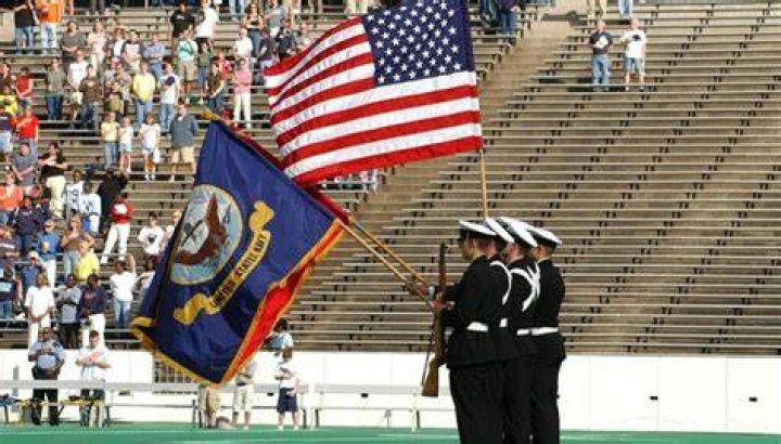 Do veterans stand at attention for the National Anthem?