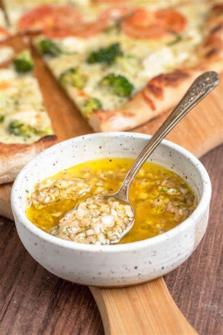 Should you put olive oil on pizza crust before the sauce?