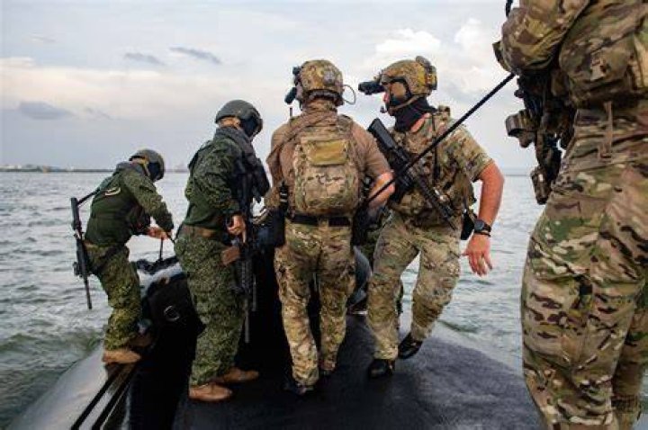 What do Navy SEALs carry into combat?