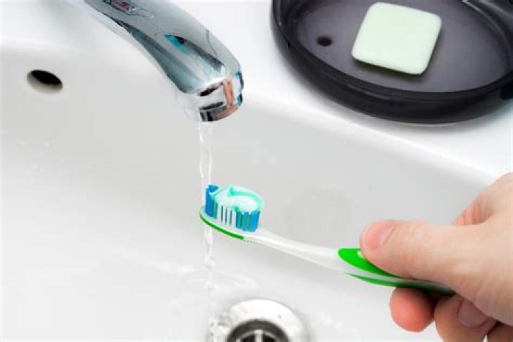 What is the proper way of using water while brushing bathing?